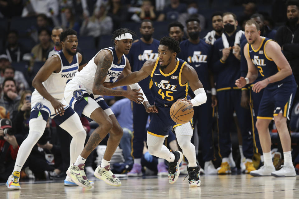 Utah Jazz guard Donovan Mitchell (45) handles the ball against Minnesota Timberwolves forward Jaden McDaniels (3) during the second half of an NBA basketball game Wednesday Dec. 8, 2021, in Minneapolis. Utah won 136-104. (AP Photo/Stacy Bengs)