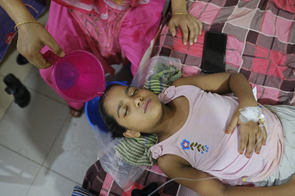 An attendant pours water on a child suffering from dengue as she receives treatment at Mugda Medical College and Hospital in Dhaka, Bangladesh, Thursday, Aug. 10, 2023. (AP Photo/Mahmud Hossain Opu)