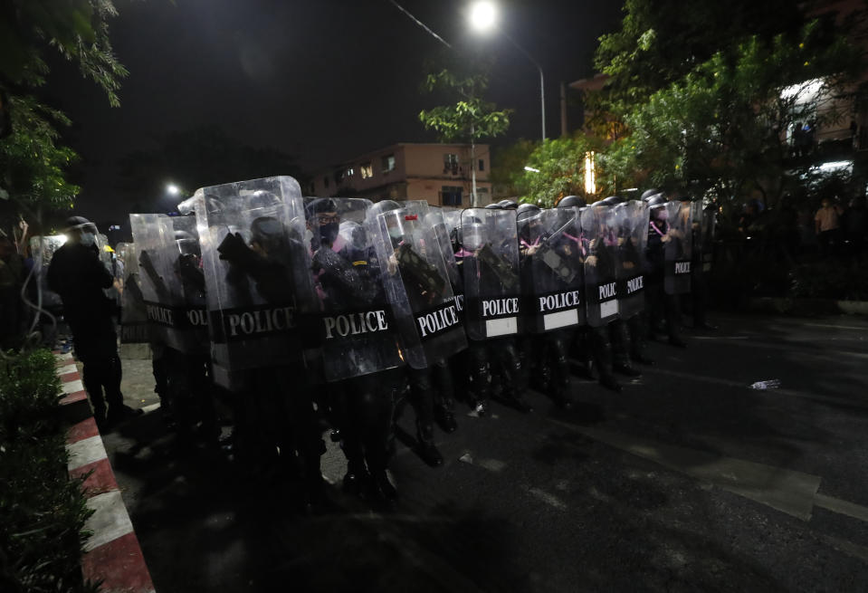 Police hold shields in tight formation as pro-democracy protesters demanding the release of pro-democracy activists march in Bangkok, Thailand, Wednesday, Feb. 10, 2021. Protesters demanded the government to step down, the constitution to be amended to make it more democratic and the monarchy be more accountable. (AP Photo/Sakchai Lalit)