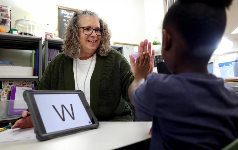 Casey DiBenedetto high-fives a student after finishing an assessment on Thursday, December 14, 2023. DiBenedetto is a pre-K teacher at Berkshire Elementary school.