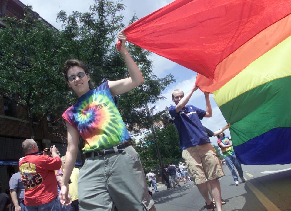 A person helps carry the rainbow flag down High street during the Pride Parade June 23, 2001 in downtown Columbus. (file)