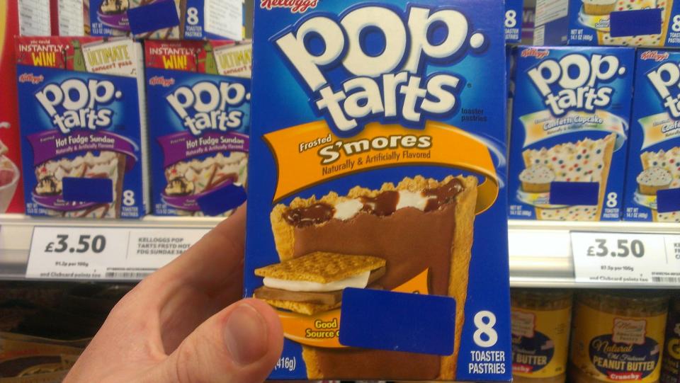 Someone holds up a box of S'mores Pop-Tarts with other flavors on the shelf and the price 3.50 in pounds sterling