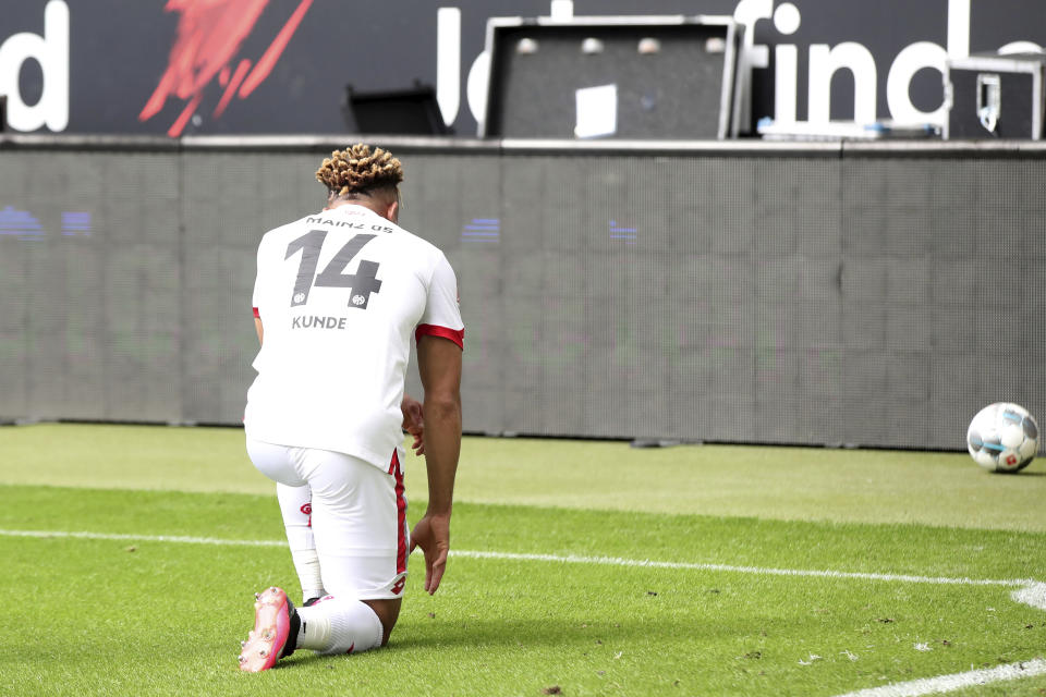 Mainz's Pierre Kunde Malong kneels as he celebrates scoring his side's 2nd goal during the German Bundesliga soccer match between Eintracht and Mainz, in Frankfurt, Germany, Saturday, June 6, 2020. Because of the coronavirus outbreak all soccer matches of the German Bundesliga take place without spectators. (Alexander Hassenstein/Pool Photo via AP)