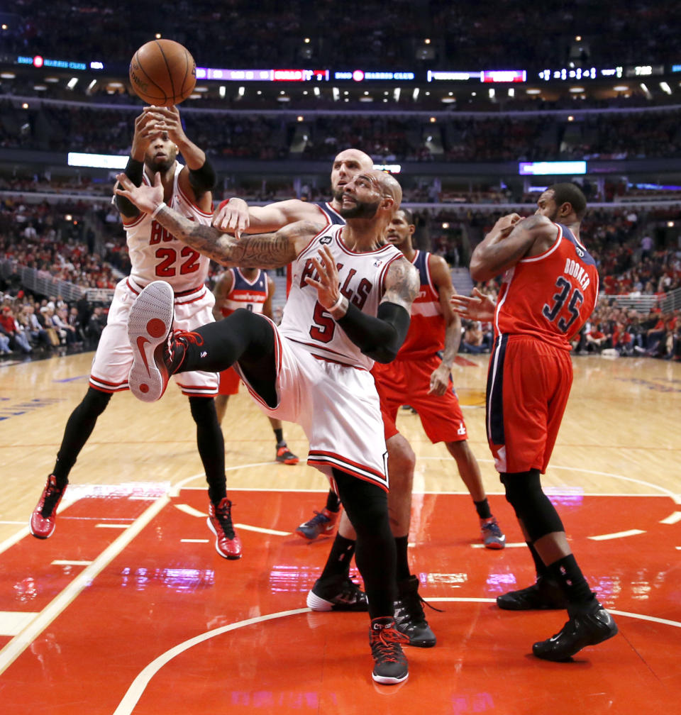 Chicago Bulls forward Taj Gibson (22) and forward Carlos Boozer (5) battle Washington Wizards center Marcin Gortat for a rebound as Trevor Booker (35) stands enar during the first half of Game 5 in an opening-round NBA basketball playoff series Tuesday, April 29, 2014, in Chicago. (AP Photo/Charles Rex Arbogast)