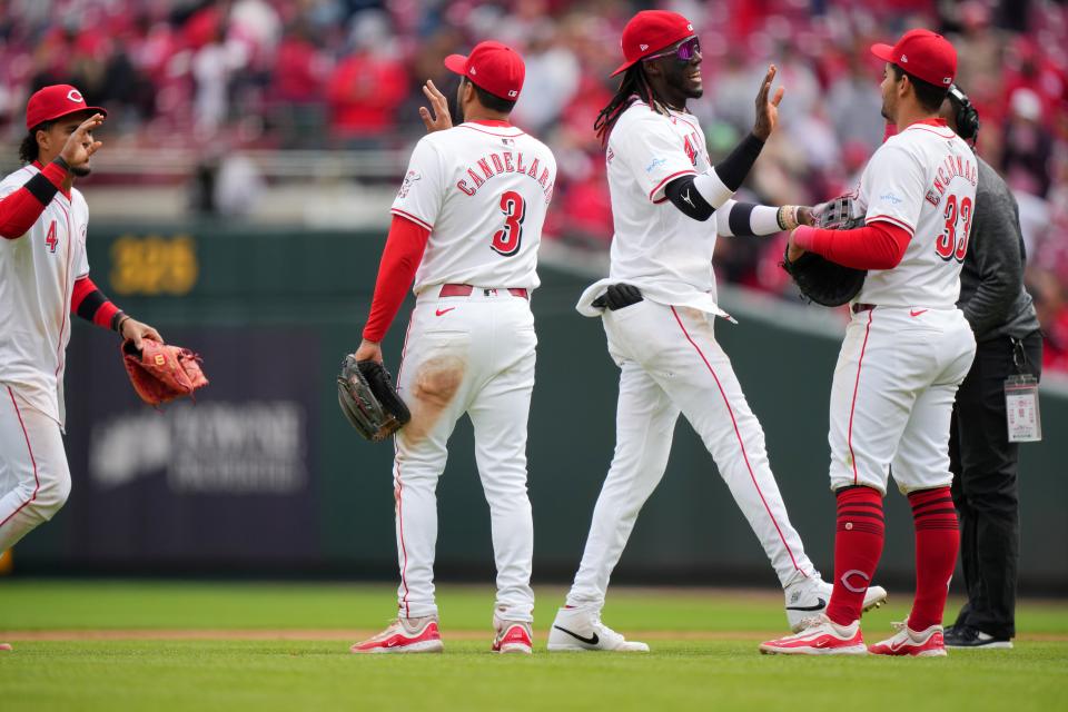 Cincinnati Reds second base Santiago Espinal (4), third base Jeimer Candelario (3), shortstop Elly De La Cruz (44) and first base Christian Encarnacion-Strand (33) celebrate the win at the conclusion of the ninth inning of a baseball game against the Los Angeles Angels, Sunday, April 21, 2024, at Great American Ball Park in Cincinnati.