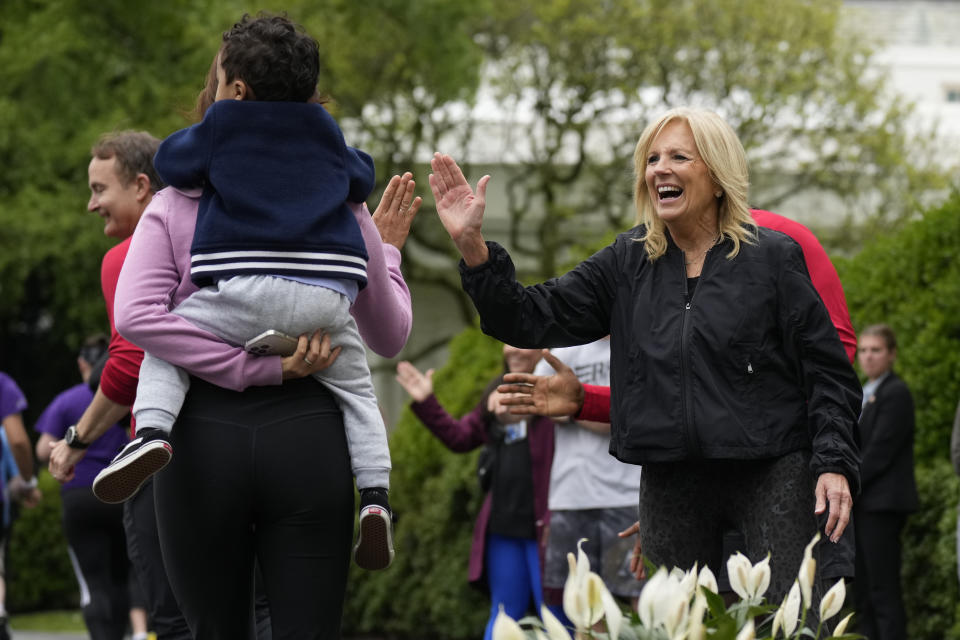 First lady Jill Biden high fives runners during the Joining Forces Military Kids Workout on the South Lawn of the White House in Washington, Saturday, April 29, 2023. The event is in honor of the Month of the Military Child. (AP Photo/Carolyn Kaster)