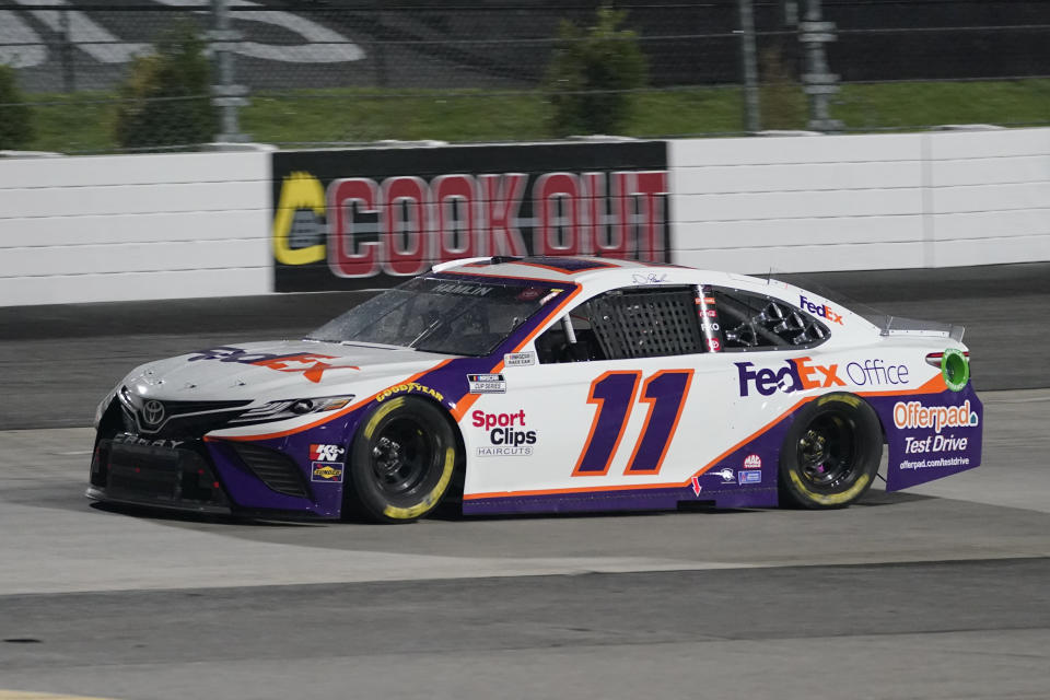 Denny Hamlin (11) leads the field in Turn 2 prior to a rain delay in the NASCAR Cup Series auto race at Martinsville Speedway in Martinsville, Va., Saturday, April 10, 2021. (AP Photo/Steve Helber)