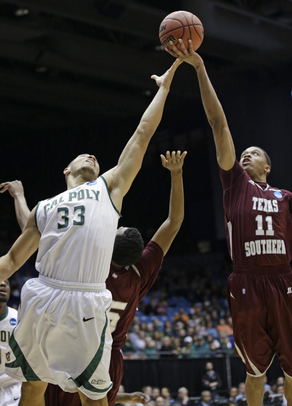 Texas Southern guard Lawrence Johnson-Danner (11) and Cal Poly forward Chris Eversley (33) go for a rebound in the first half of a first-round game of the NCAA college basketball tournament on Wednesday, March 19, 2014, in Dayton, Ohio. (AP Photo/Al Behrman)