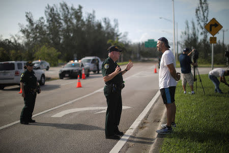 A local resident talks with a police officer as he is trying to enter the Florida Keys road after Hurricane Irma strikes Florida, in Homestead, Florida, U.S., September 11, 2017. REUTERS/Carlos Barria