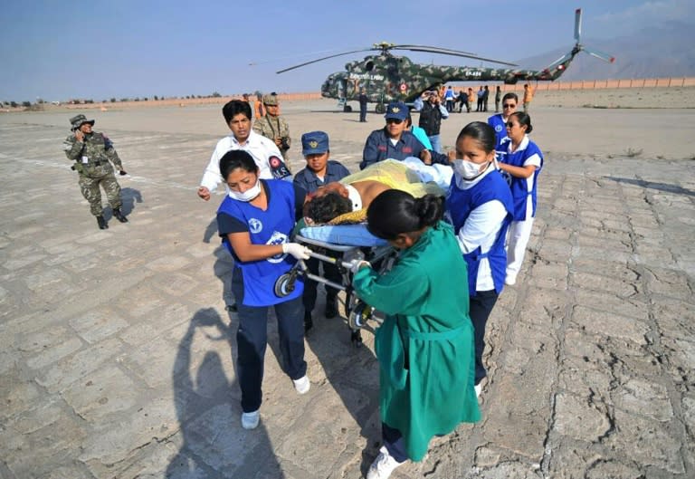 A medical team carry a person injured in the bus crash near the southern Peruvian town of Ocona, which killed at least 44 people