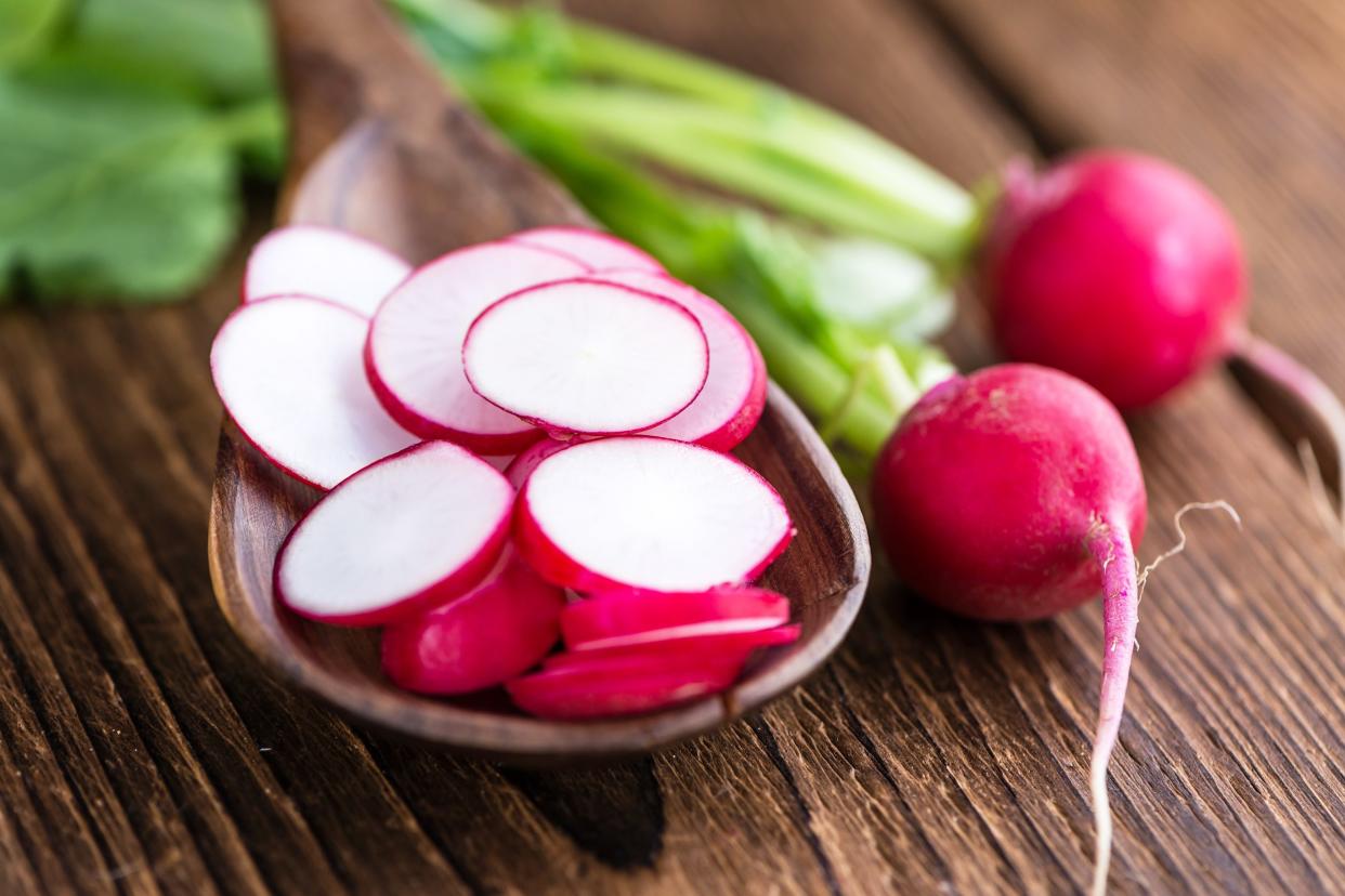 sliced radishes on wooden background