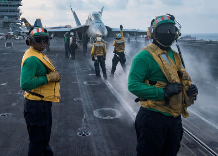 Sailors conduct flight operations on the aircraft carrier USS Carl Vinson (CVN 70) flight deck, in the South China Sea April 8, 2017. Picture taken April 8, 2017. U.S. Navy photo by Mass Communication Specialist 3rd Class Matt Brown/Handout via REUTERS