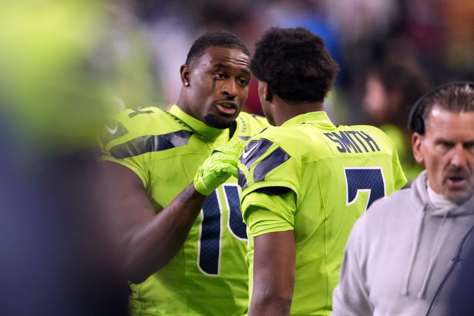 Seattle Seahawks wide receiver DK Metcalf (14) talks with quarterback Geno Smith in the bench area during the first half of an NFL football game against the San Francisco 49ers, Thursday, Nov. 23, 2023, in Seattle. (AP Photo/Lindsey Wasson)