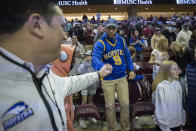 Hofstra fan Sammy Martin, center, fist bumps a team member after the second half of an NCAA college basketball game against Charleston, Saturday, Jan. 28, 2023, in Charleston, S.C. (AP Photo/Stephen B. Morton)