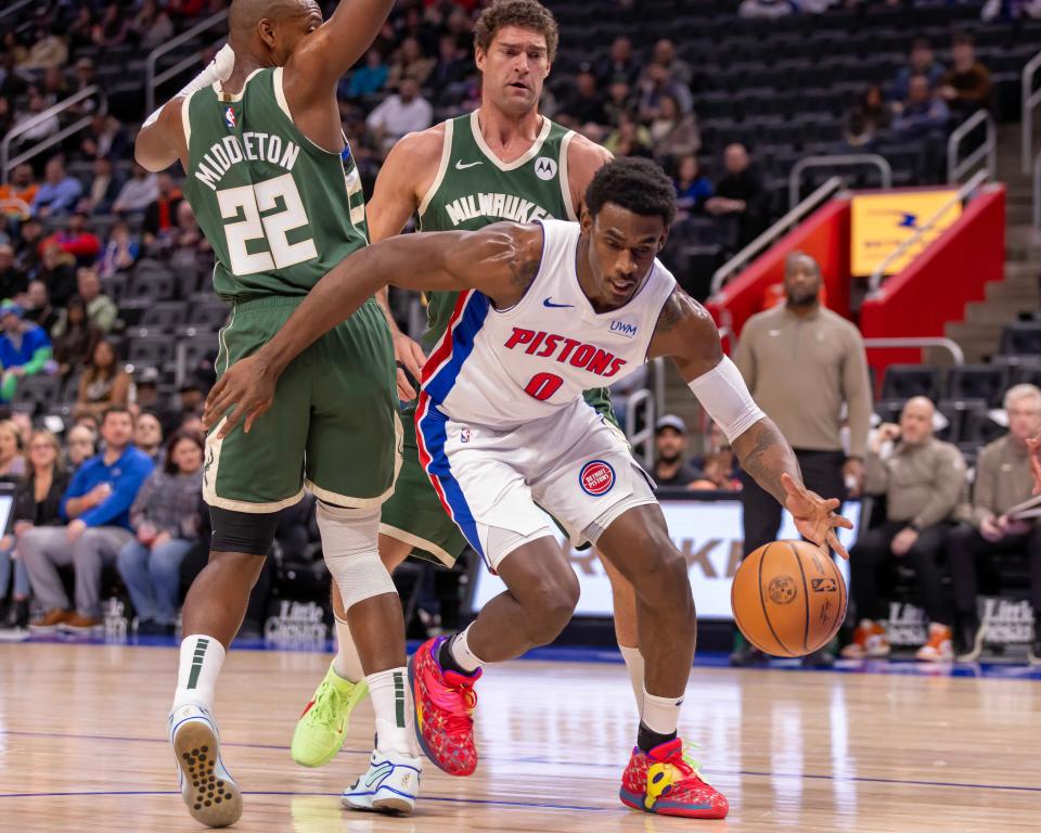 Jan 22, 2024; Detroit, Michigan, USA; Detroit Pistons center Jalen Duren (0) controls the ball next to Milwaukee Bucks forward Khris Middleton (22) during the first quarter at Little Caesars Arena. Mandatory Credit: David Reginek-USA TODAY Sports