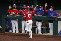 Texas Rangers' Robinson Chirinos (61) celebrates with coaching staff Don Wakamatsu, from left rear, manager Chris Woodward, Julio Rangel, and Hector Ortiz after Chirinos scored in the fourth inning of a baseball game against the Los Angeles Angels in Arlington, Texas, Friday, Aug. 7, 2020. (AP Photo/Tony Gutierrez)