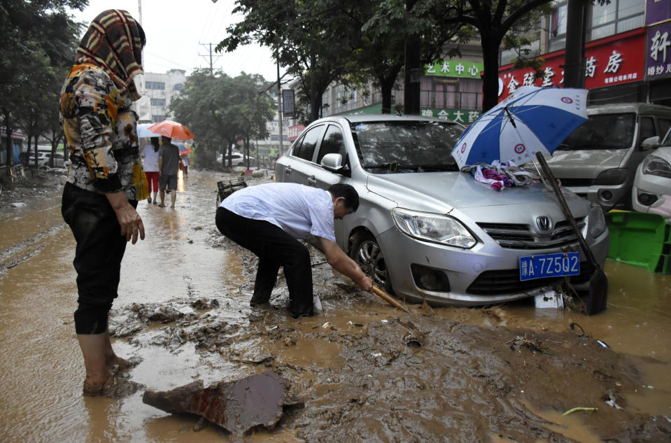 In this photo released by Xinhua News Agency, residents clean up the aftermath of a flood in Mihe Town of Gongyi City, in central China's Henan province on Wednesday, July 21, 2021. China's military has blasted a dam to release floodwaters threatening one of its most heavily populated provinces, as the death toll in widespread flooding rose to more than two dozens. (Han Chaoyang/Xinhua via AP)