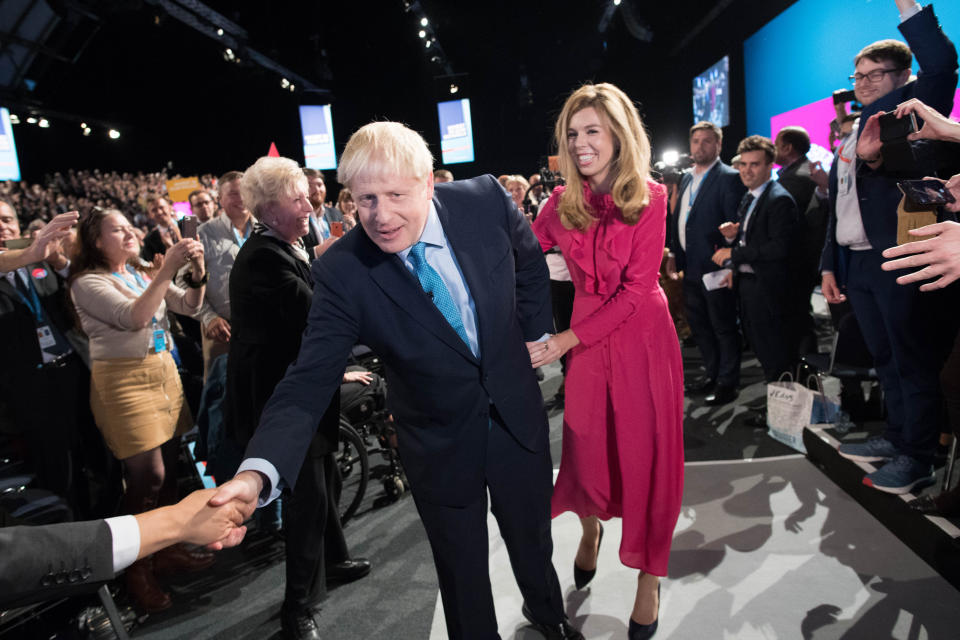 Prime Minister Boris Johnson leaves the stage with his partner Carrie Symonds after delivering his speech during the Conservative Party Conference at the Manchester Convention Centre. (Photo by Stefan Rousseau/PA Images via Getty Images)