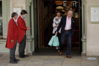 A doorman wearing a face shield and mask to protect from coronavirus stands outside the main entrance of the Fortnum & Mason department store as customers leave carrying shopping bags in the Piccadilly area of central London, Friday, May 22, 2020. The store reopened its food hall department for customers to enter yesterday as part of a phased reopening as the British government is beginning to relax aspects of its nationwide coronavirus lockdown. (AP Photo/Matt Dunham)