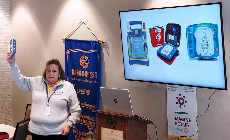 Kimberly Parsley shows Rotarians one of several models of small, easy-to-use defibrillators.