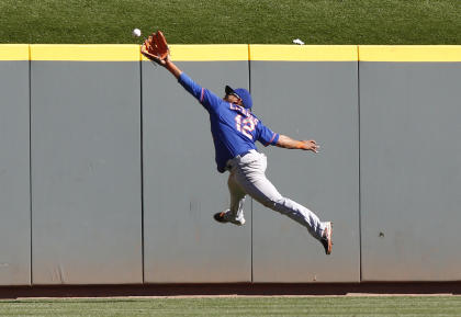 Mets center fielder Juan Lagares can't quite reach a fly ball from Reds third baseman Jack Hannahan. (USA Today)