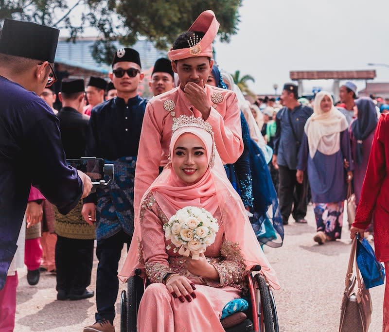 Amirul Syahmi Mohd Yazid with his wheelchair bound wife Siti Aishah Zaid at a marriage solemnisation event. – Picture via Facebook