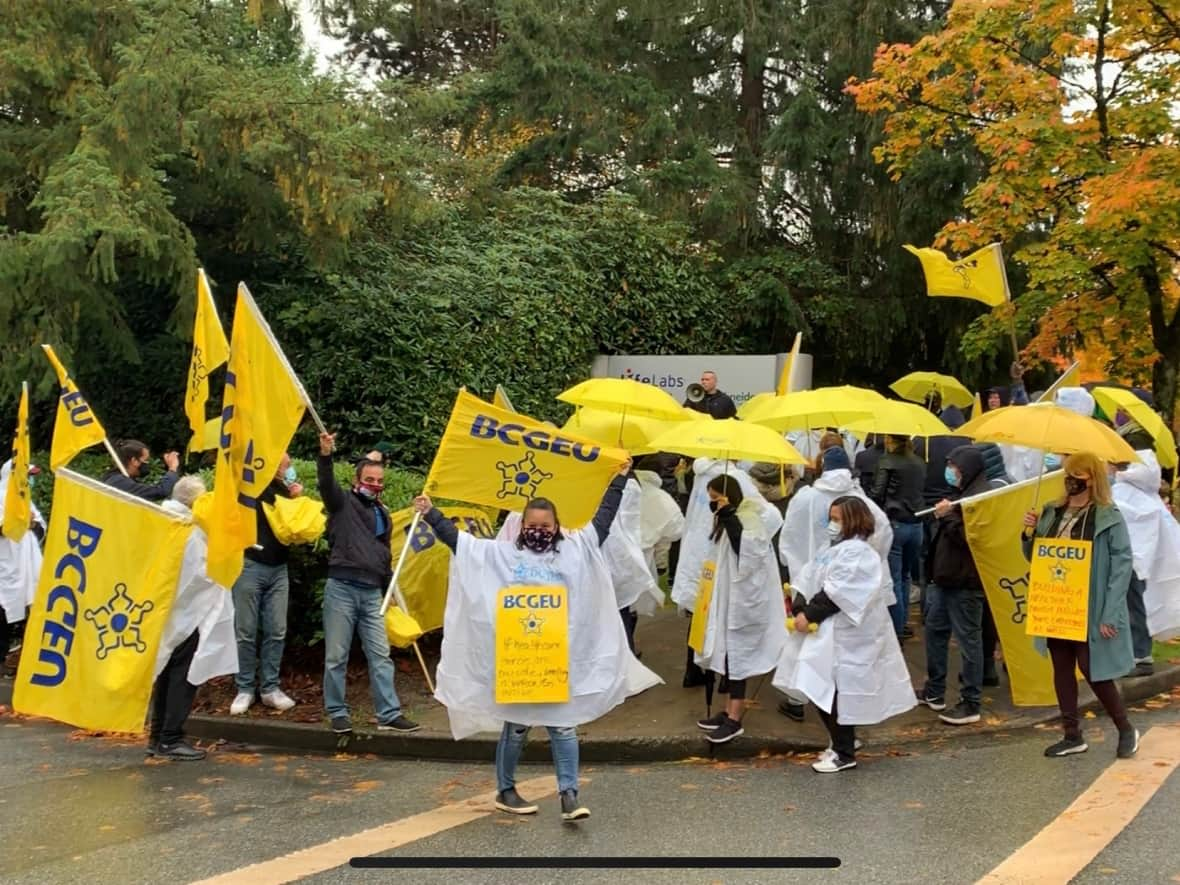 LifeLabs employees rally outside the company's Burnaby Reference Laboratory on Saturday, Oct. 23, 2021. (Jon Hernandez/CBC - image credit)