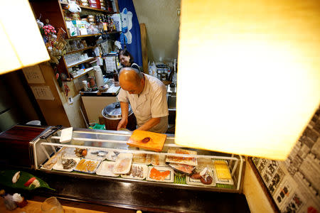 Masatoshi Fukutsuna, chef and owner of sushi restaurant Eiraku, and his wife Mitsue cook sushi dish at their restaurant in Tokyo, Japan December 7, 2018. Picture taken December 7, 2018.REUTERS/Issei Kato