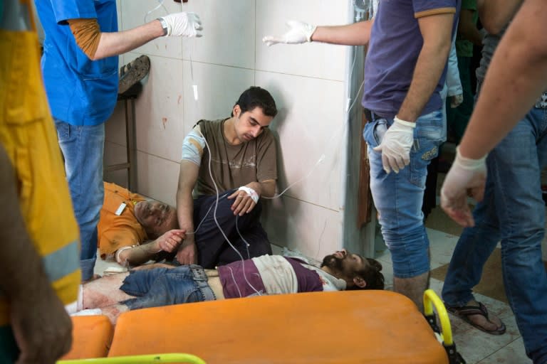 Syrians receive treatment at a makeshift hospital following air strikes on rebel-held eastern areas of Aleppo on September 24, 2016