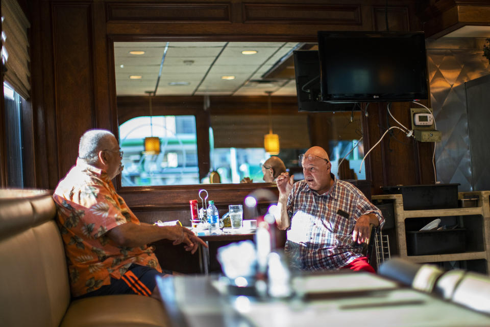 People wait for their breakfast inside of a local diner on Friday, Sept. 4, 2020, in Hoboken, N.J. Tape measures will join tapas as social distancing becomes essential to the ambiance at New Jersey restaurants preparing for the limited resumption Friday of indoor dining. Gov. Phil Murphy gave the go-ahead on Monday for indoor dining not to exceed 25% of capacity. (AP Photo/Eduardo Munoz Alvarez)