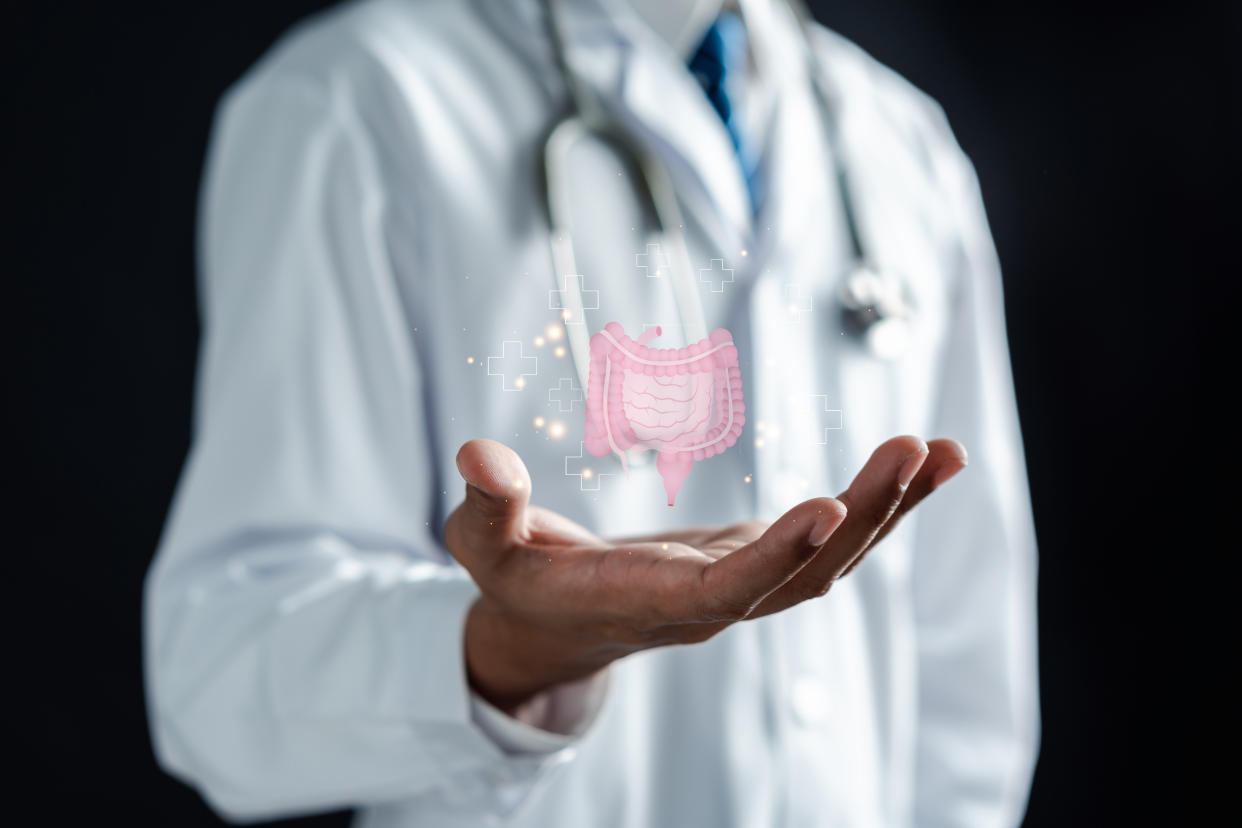 doctor in a white coat hands holding stomach with intestine virtual icon, probiotics food for gut health, Yahoo Canada spoke to a leading researcher on why cases of IBD could be rising in Canadian youth. (Getty Images)