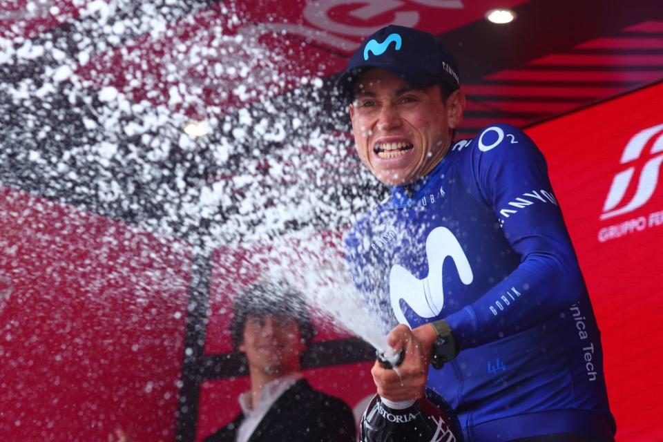 Movistar Teams Colombian rider Einer Rubio sprays sparkling wine as he celebrates on the podium after winning the thirteenth stage of the Giro dItalia 2023 cycling race which start was transfered from Borgofranco dIvrea to Le Chable in Switzerland due to bad weather conditions and CransMontana on May 19 2023 Photo by Luca Bettini  AFP Photo by LUCA BETTINIAFP via Getty Images