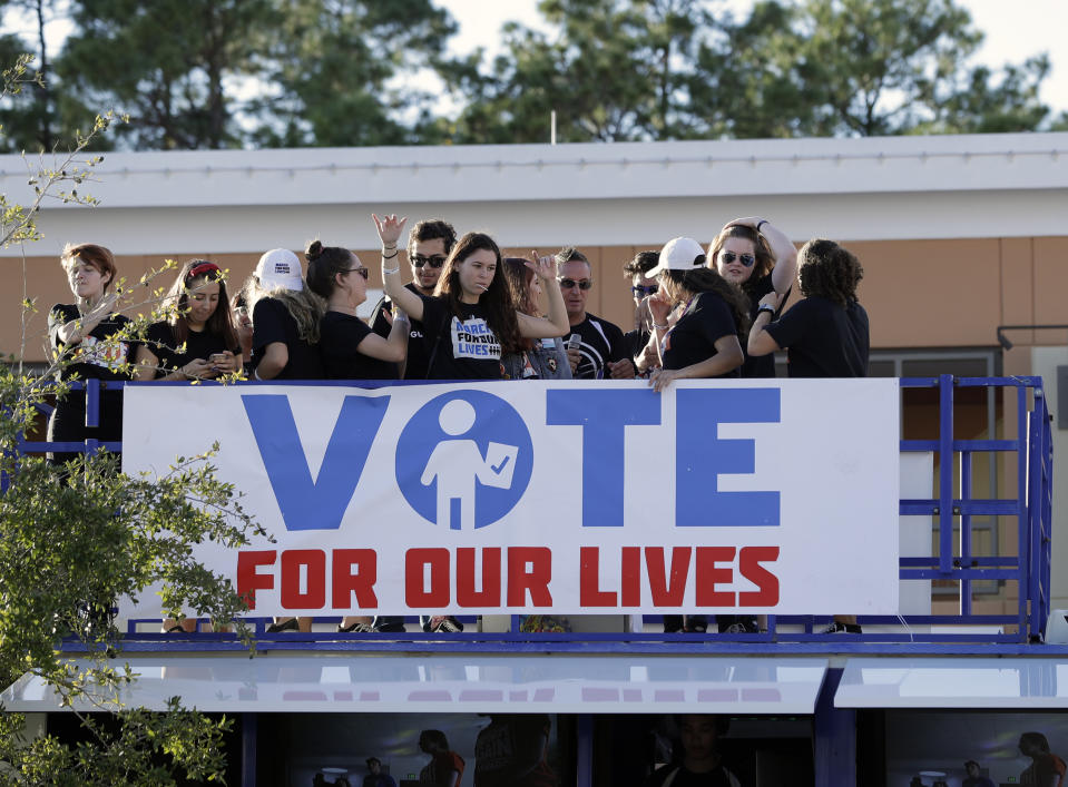 In this Wednesday, Oct. 31, 2018 photo, students dance atop a bus to music during a Vote for Our Lives rally at the University of Central Florida in Orlando, Fla. Nine months after 17 classmates and teachers were gunned down at their Florida school, Parkland students are finally facing the moment they’ve been leading up to with marches, school walkouts and voter-registration events throughout the country: their first Election Day. (AP Photo/John Raoux)