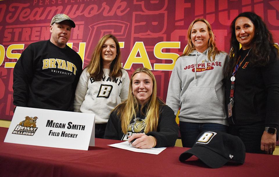 Case field hockey player Megan Smith, middle, is surrounded by, from left, Larry Smith, Amy Smith, head coach Kacie Martel and assistant coach Tammy Greene after signing a national letter of intent at Joseph Case High School on Monday, Nov, 13, 2023.