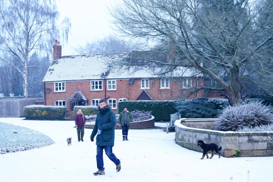 People walk in St Nicholas' Park after overnight snow showers in Warwick. Parts of the UK are being hit by freezing conditions with the UK Health Security Agency (UKHSA) issuing a Level 3 cold weather alert covering England until Monday and the Met Office issuing several yellow weather warnings for snow and ice in parts of the UK over the coming days. Picture date: Sunday December 11, 2022.