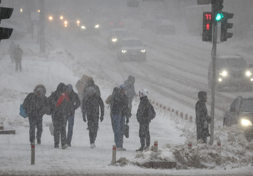 People walk down a street amid a snowfall as Russia's invasion of Ukraine continues, in central Kyiv, Ukraine December 7, 2022.  REUTERS/Gleb Garanich