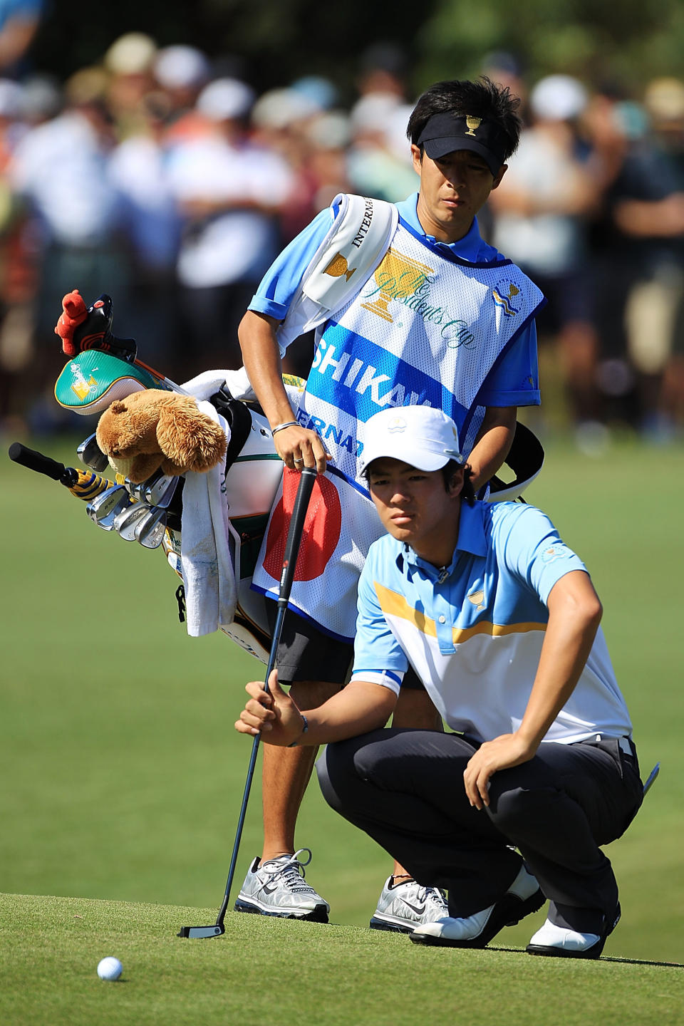 MELBOURNE, AUSTRALIA - NOVEMBER 18: Ryo Ishikawa of the International Team lines up a putt on the first hole with his caddie caddie Hiroyuki Kato during the Day Two Four-Ball Matches of the 2011 Presidents Cup at Royal Melbourne Golf Course on November 18, 2011 in Melbourne, Australia. (Photo by Scott Halleran/Getty Images)