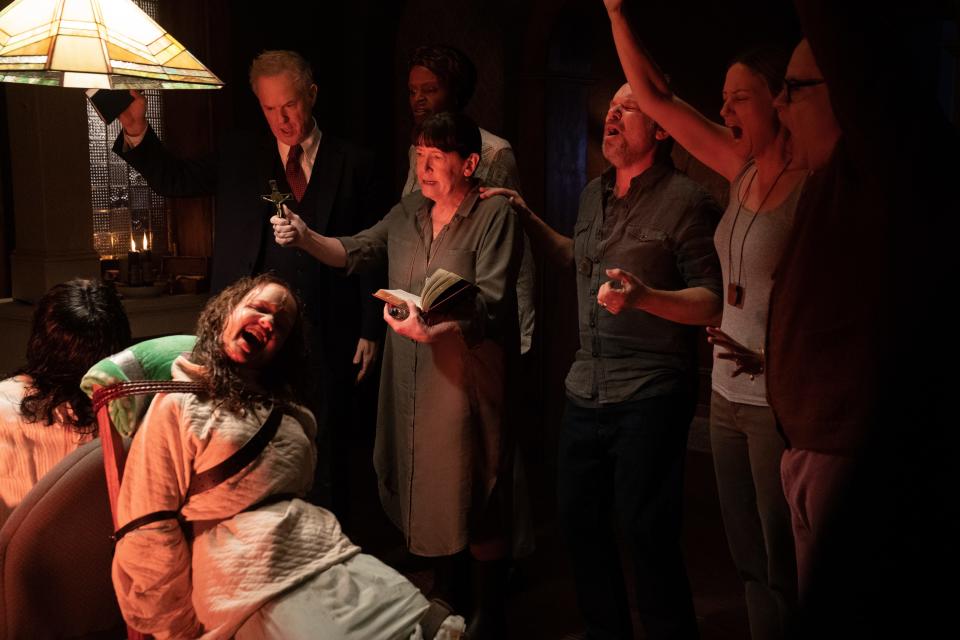 A nurse (Ann Dowd, center) leads a bunch of grown-ups desperately trying to rid two girls of a demonic presence in "The Exorcist: Believer."