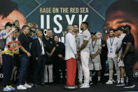 FILE - Heavyweight boxers Britain's Anthony Joshua, center right, and Ukraine's Oleksandr Usyk, center left, face off during a weigh-in at King Abdullah Sports City in Jeddah, Saudi Arabia, Friday, Aug. 19, 2022. Saudi Arabia's most recent venture into the global sports scene — purchasing a stake in the Professional Fighters League — is yet another example of the oil-rich kingdom using athletics to increase its influence.(AP Photo/Hassan Ammar, File)