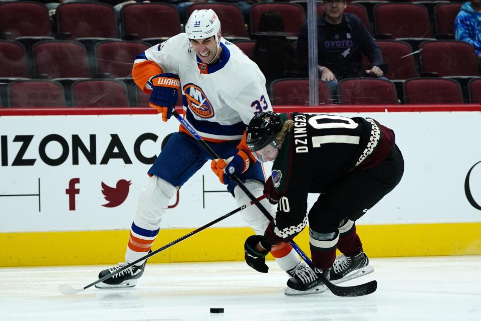 New York Islanders defenseman Zdeno Chara (33) battles with Arizona Coyotes left wing Ryan Dzingel (10) for the puck during the first period of an NHL hockey game Saturday, Oct. 23, 2021, in Glendale, Ariz. (AP Photo/Ross D. Franklin)