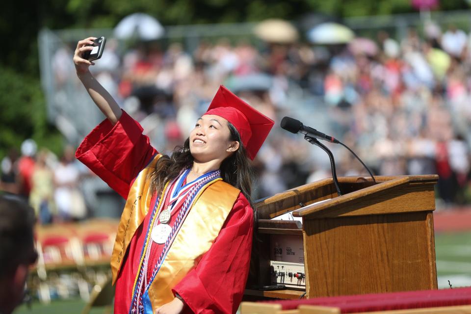 Salutatorian Stephanie Wong takes a selfie during the graduation ceremony at Milford High School, June 12, 2022.