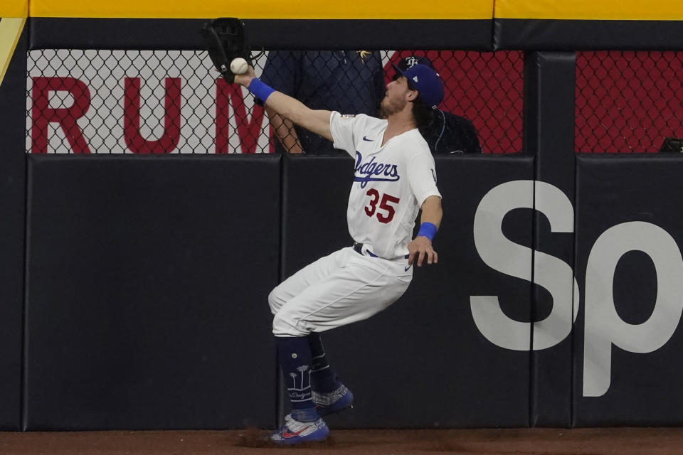 Los Angeles Dodgers center fielder Cody Bellinger can't gets a glove on a double by Tampa Bay Rays' Joey Wendle during the seventh inning in Game 1 of the baseball World Series Tuesday, Oct. 20, 2020, in Arlington, Texas. (AP Photo/Tony Gutierrez)