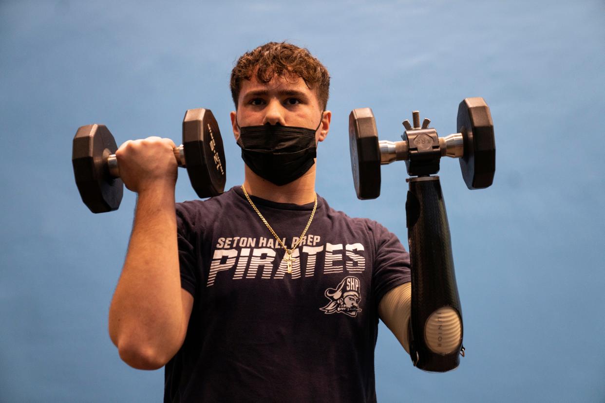 Alex Manna, 16, from Montville, received a prosthetic hand funded by Born to Run, a nonprofit founded by Paralympian Noelle Lambert. Manna uses dumbbells at the Wayne YMCA on Friday, January, 14, 2022.