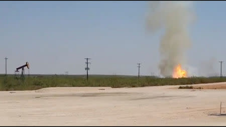 FILE PHOTO: A pipeline explosion erupts in this image captured from video by a field worker in Midland County, the home to the Permian Basin and the largest U.S. oilfield, in Texas, U.S., August 1, 2018. Courtesy Marty Baeza/Handout via REUTERS/File Photo