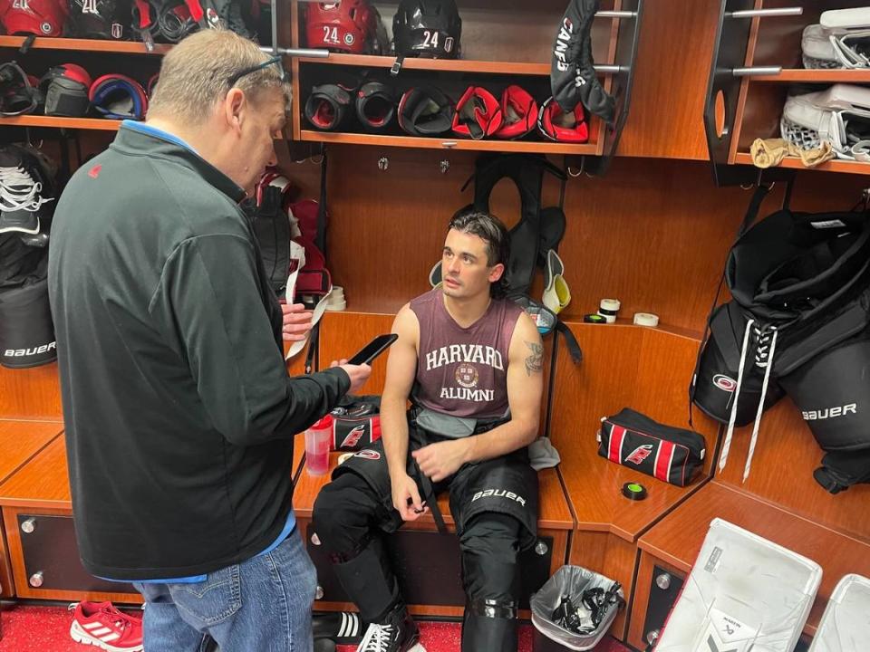 Carolina Hurricanes forward Seth Jarvis speaks to a reporter while wearing his beloved Harvard alumni T-shirt, a gift from teammate and actual Harvard alum Jack Drury.