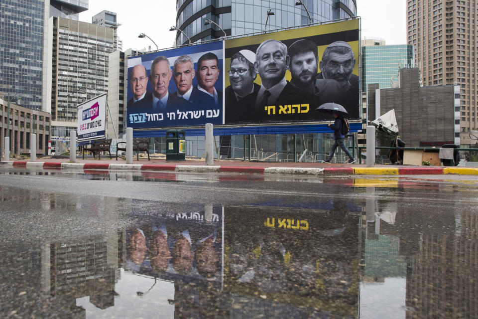 FILE - In this Saturday, March 16, 2019 file photo, an Ultra-Orthodox Jewish man looks at an elections billboards of the Blue and White party leaders, from left to right, Moshe Yaalon, Benny Gantz, Yair Lapid and Gabi Ashkenazi, alongside a panel on the right showing Prime Minister Benjamin Netanyahu flanked by extreme right politicians, from the left, Itamar Ben Gvir, Bezalel Smotrich and Michael Ben Ari in Ramat Gan, Israel, In a charged campaign that has been heavy on insults and short on substance, Israel's conflict with the Palestinians has been notably absent from the discourse. Hebrew reads on the left billboard "The nation of Israel lives" and on the right billboard "Kahana Lives" in a reference to a banned ultranationalist party. (AP Photo/Oded Balilty, File)