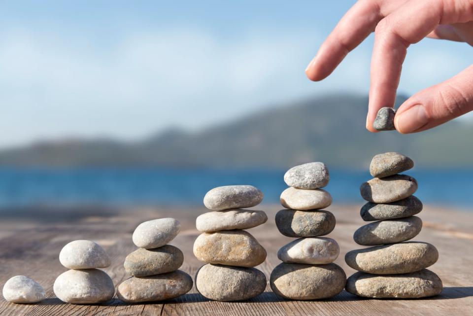 A person stacking stones in increasingly taller towers. 