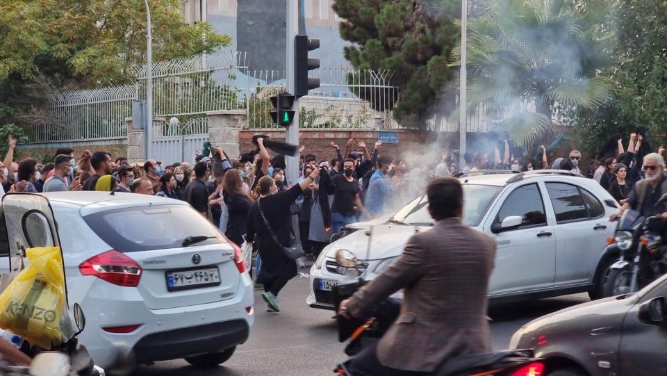 Several cars are unable to move through thousands of demonstrators.