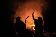 Children engage in a sword fight, backdropped by a campfire, during the Romula Fest historic reenactment festival in the village of Resca, Romania, Saturday, Sept. 3, 2022. (AP Photo/Andreea Alexandru)