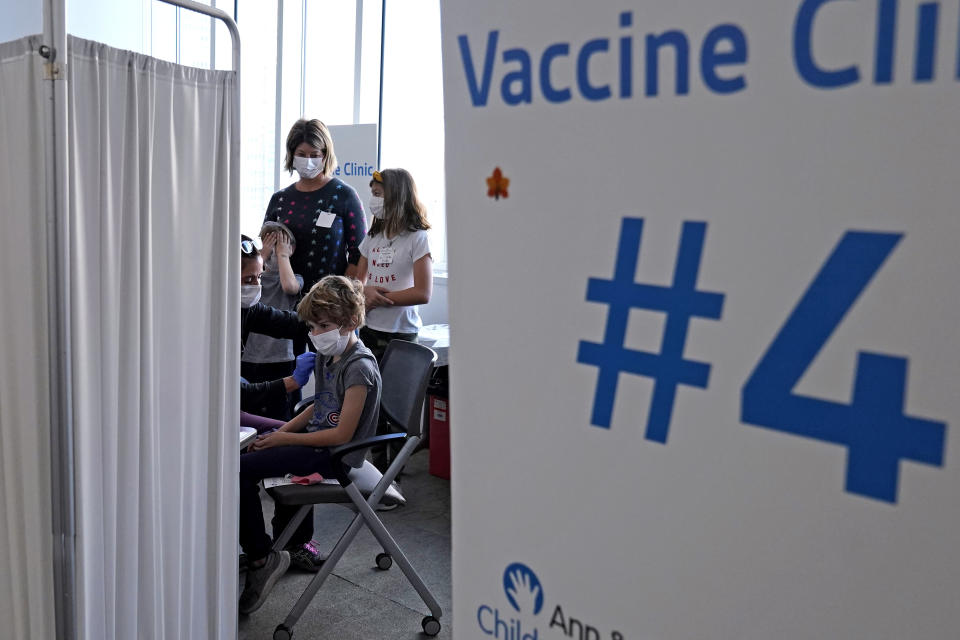 FILE - Graham Roark, 8, receives the Pfizer COVID-19 vaccine for children 5 to 11 years from Lurie Children's hospital registered nurse Virginia Scheffler at the hospital Nov. 5, 2021, in Chicago. First shots are averaging about 300,000 per day. (AP Photo/Nam Y. Huh, File)